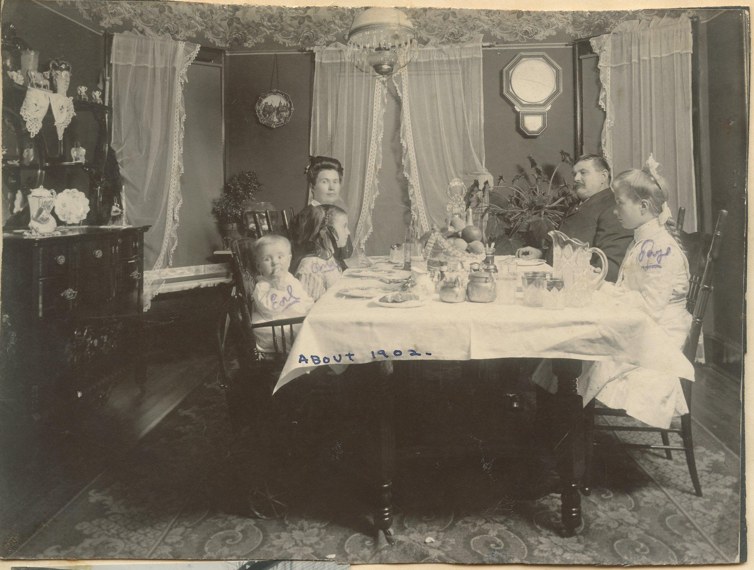 Portrait of Henry and Millie Fritz’s family at the dinner table.